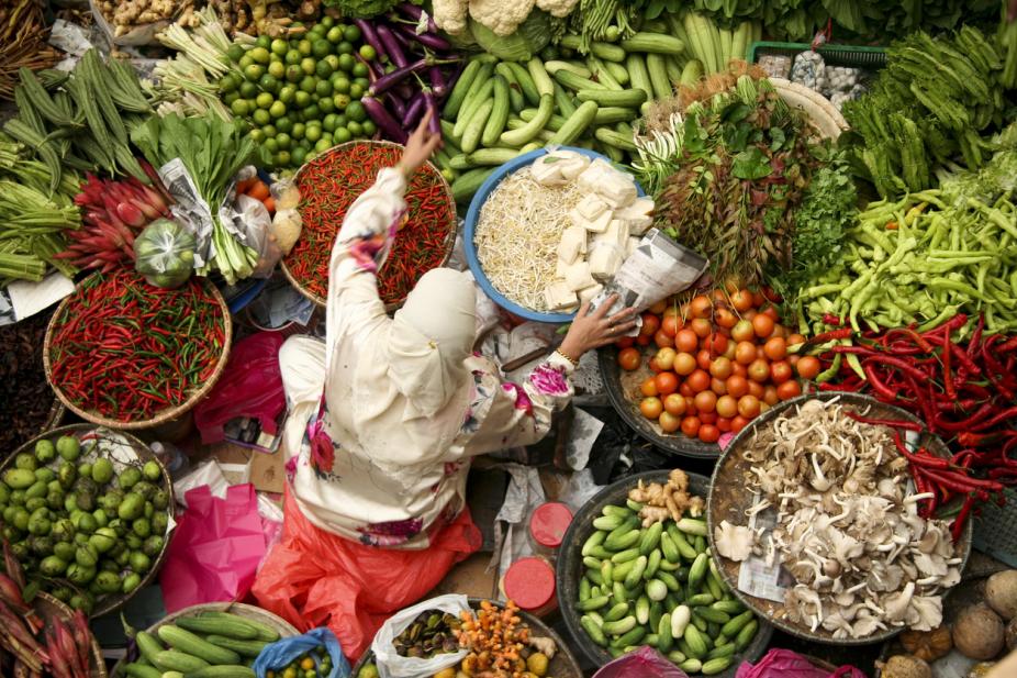 muslim woman selling fresh vegetables at market in kota baru malaysia. iStock