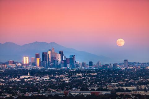Superman moonrise over the downtown Los Angeles slightly smoggy skyline and the San Gabriel Mountains, as seen from the Baldwin Hills Scenic Overlook