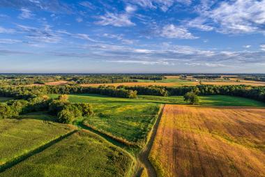 An aerial drone photo over the fields and dirt road lanes in the fields during the golden light of the morning. iStock